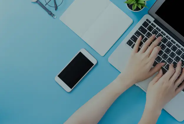 パソコンを操作する人とスマートフォンの写真